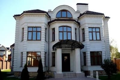 Выполненный белый классический фасад частного дома из натурального камня